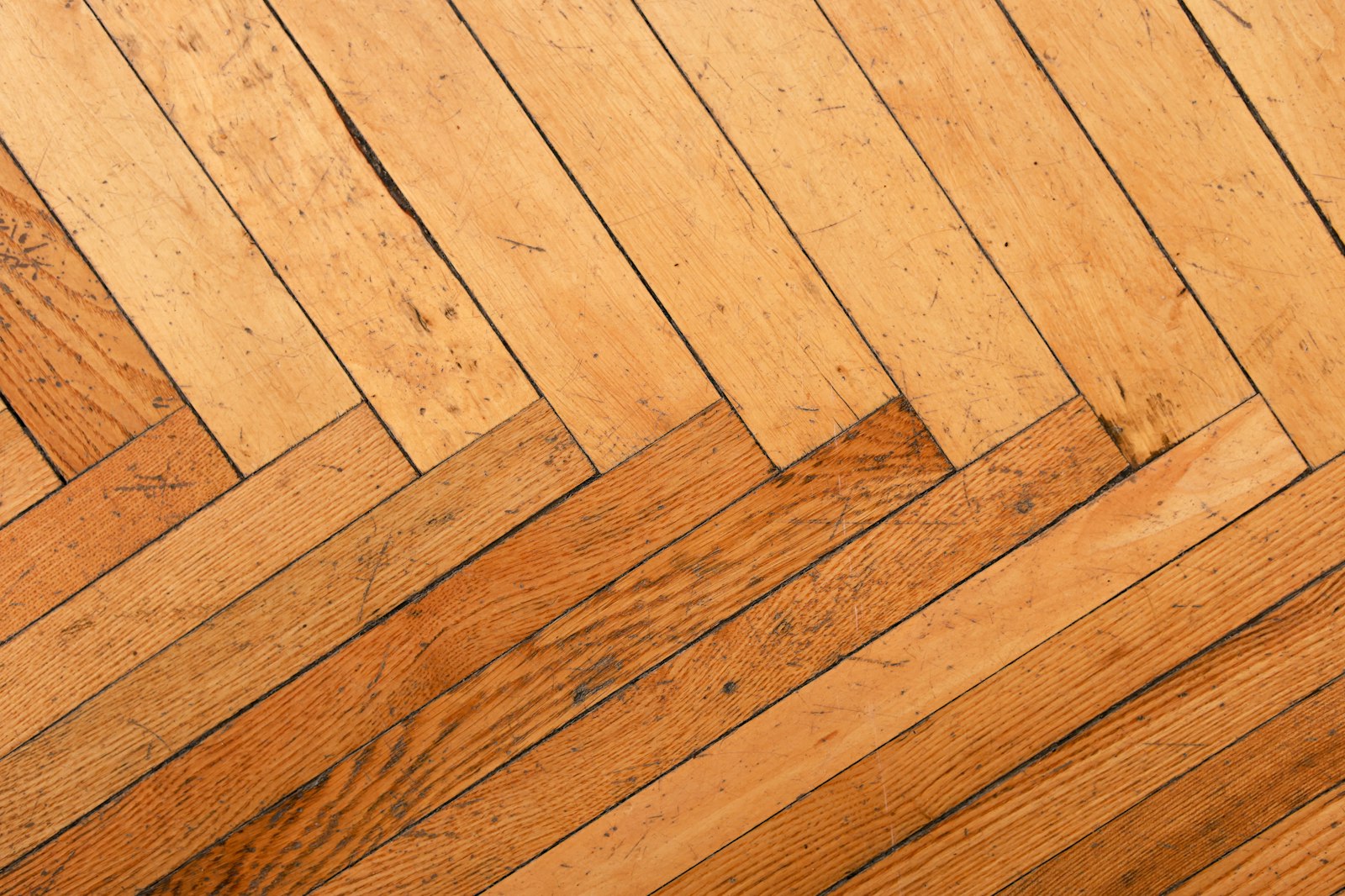 A herringbone wooden floor in warm tones