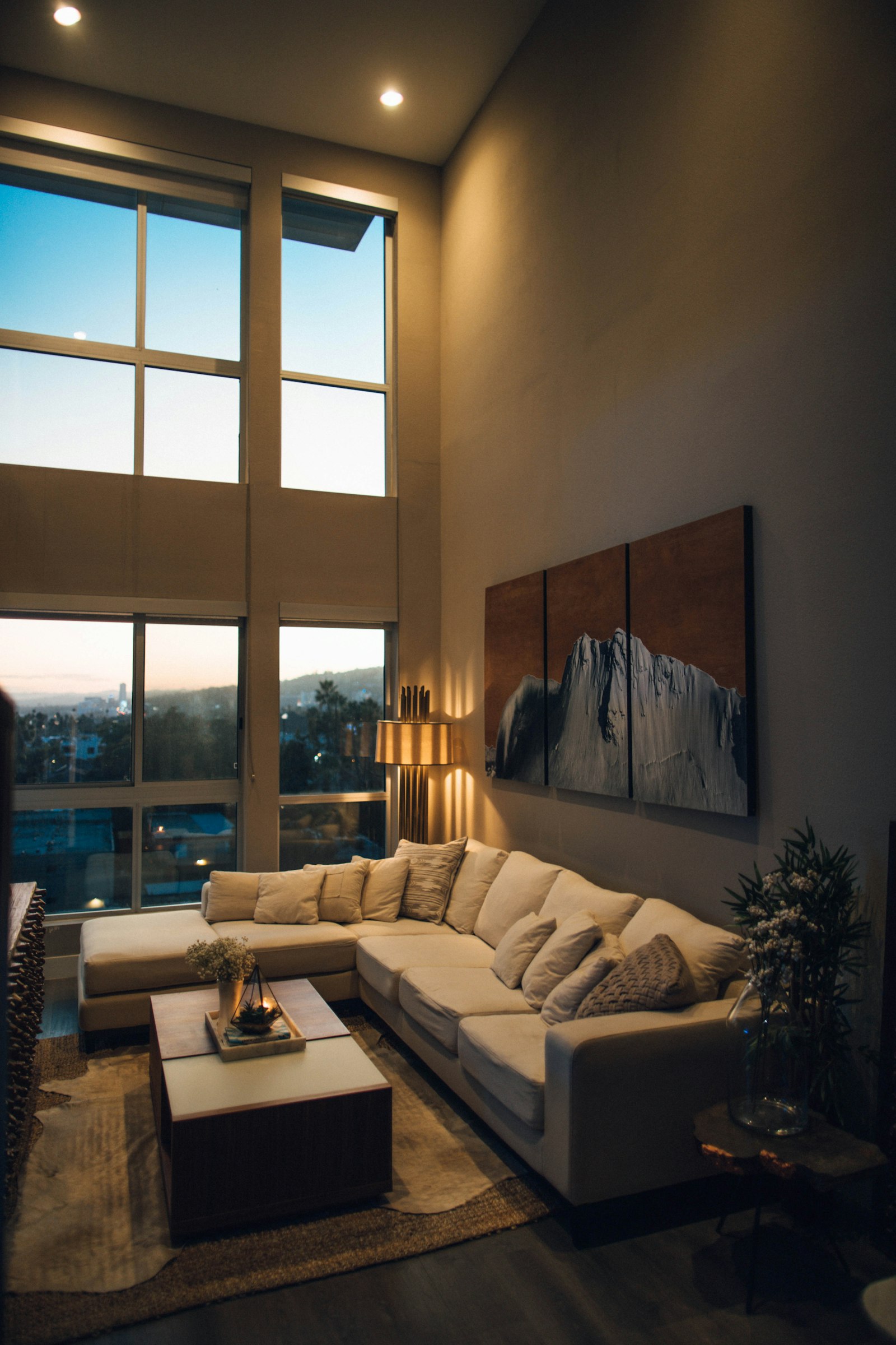 A warm living room with a large window and wall art